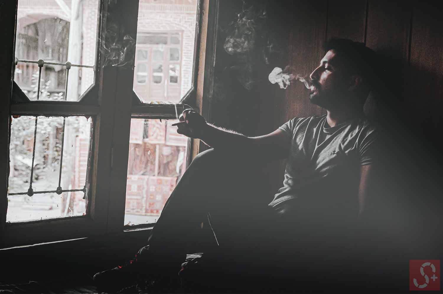 A person is smoking beside window