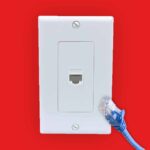 Ethernet port with ethernet cable in front red background